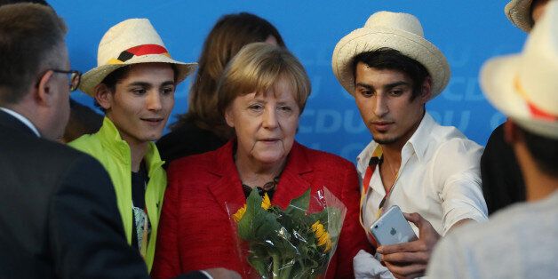 SCHWERIN, GERMANY - SEPTEMBER 19:  German Chancellor and Christian Democrat (CDU) Angela Merkel poses for a photo with Syrian refugees after she spoke at an election campaign stop on September 19, 2017 in Schwerin, Germany. Merkel is seeking a fourth term in German federal elections scheduled for September 24 and currently has a double-digit lead over her main rival, German Social Democrat (SPD) Martin Schulz.  (Photo by Sean Gallup/Getty Images)