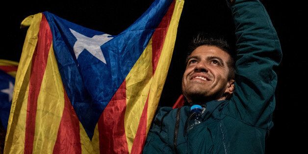 BARCELONA, SPAIN - OCTOBER 01:  People wave Catalan flags as they dance and sing after listening to Catalan President Carles Puigdemont speak via a televised press conference as they await the result of the Indepenence Referendum at the Placa de Catalunya  on October 1, 2017 in Barcelona, Spain. More than five million eligible Catalan voters are estimated to visit 2,315 polling stations today for Catalonia's referendum on independence from Spain. The Spanish government in Madrid has declared the