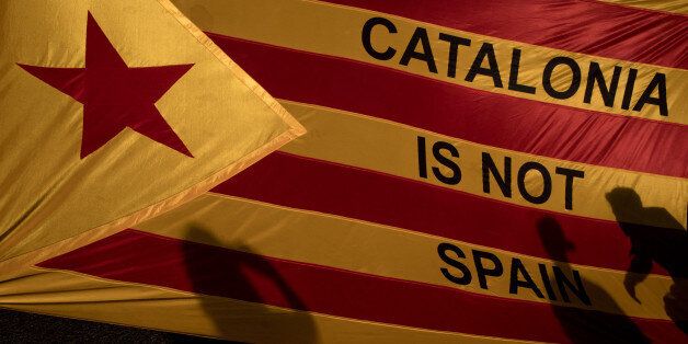 BARCELONA, SPAIN - OCTOBER 03:  Protesters shadows are seen on a Catalan flag as thousands of citizens gather in Plaza Universitat during a regional general strike to protest against the violence that marred Sunday's referendum vote on October 3, 2017 in Barcelona, Spain. According to the Catalonia's government more than two million people voted on Sunday in the referendum of Catalonia, which the Government in Madrid had declared illegal and undemocratic. Officials said that 90% of votes cast we