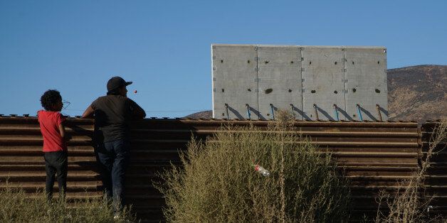 TIJUANA, MEXICO - OCTOBER 5:  People watch  prototype sections of a border wall between Mexico and the United States under construction on October 5, 2017 in Tijuana, Mexico. Prototypes of the border wall propopsed by President Donald Trump are being built just north of the U.S.- Mexico border, where competitors who are hoping to gain approval to build the wall have until the first of next month to complete their work. (Photo by Sandy Huffaker/Getty Images)