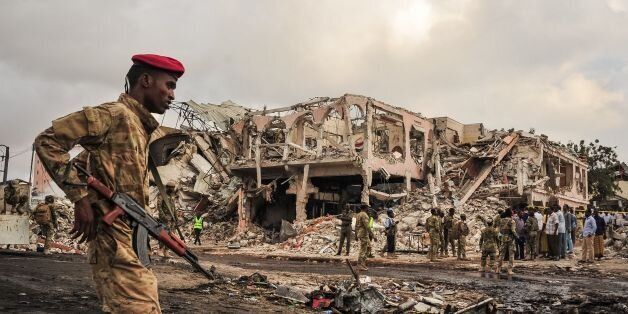 TOPSHOT - EDITORS NOTE: Graphic content / Somali soldiers patrol on the scene of the explosion of a truck bomb in the centre of Mogadishu, on October 15, 2017.A truck bomb exploded outside a hotel at a busy junction in Somalia's capital Mogadishu on October 14, 2017 causing widespread devastation that left at least 20 dead, with the toll likely to rise. / AFP PHOTO / Mohamed ABDIWAHAB        (Photo credit should read MOHAMED ABDIWAHAB/AFP/Getty Images)