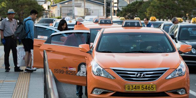 Passengers board taxis outside Seoul Station in Seoul, South Korea, on Monday, May 25, 2015. South Korea is scheduled to release revised first-quarter gross domestic product figures on June 4. Photographer: SeongJoon Cho/Bloomberg via Getty Images