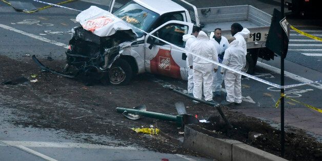 Investigators inspect a truck following a shooting incident in New York on October 31, 2017. Several people were killed and numerous others injured in New York on Tuesday after a vehicle plowed into a pedestrian and bike path in Lower Manhattan, police said. 'The vehicle struck multiple people on the path,' police tweeted. 'The vehicle continued south striking another vehicle. The suspect exited the vehicle displaying imitation firearms & was shot by NYPD.' / AFP PHOTO / DON EMMERT        (Photo