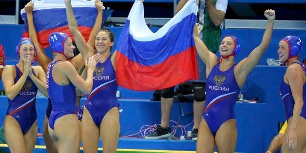 2016 Rio Olympics - Water Polo - Final - Women's Bronze Medal Match Hungary v Russia - Olympic Aquatics Stadium - Rio de Janeiro, Brazil - 19/08/2016. Russian players hold a Russian flag as they celebrate their win over Hungary. REUTERS/Laszlo Balogh FOR EDITORIAL USE ONLY. NOT FOR SALE FOR MARKETING OR ADVERTISING CAMPAIGNS.