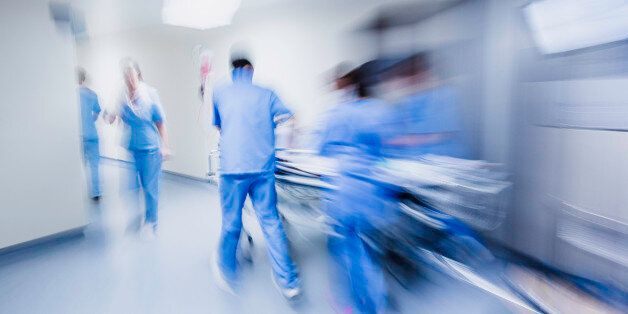 Doctors and nurses pulling hospital trolley,