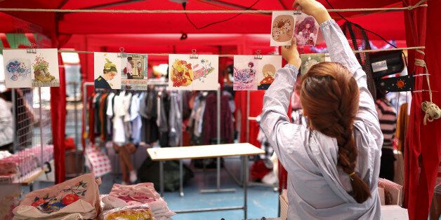 Ho Chi Minh city, Viet Nam - December 10, 2016: A young girl is hanging handmade postcards in the souvenir booth at a flea market in Ho Chi Minh city,  Viet Nam