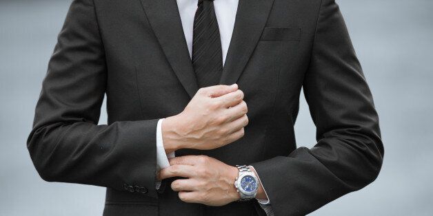 Close up of businessman wearing suit and watch.