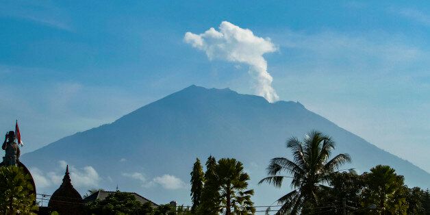 Mount Agung volcano spews steam and smoke into the air as seen from Bangli on Indonesia's resort island of Bali on October 23, 2017.Thousands of residents who fled a rumbling volcano on the island of Bali are refusing to leave evacuation centres after being told to return to their homes outside of the immediate danger zone. / AFP PHOTO / AGUS RANU        (Photo credit should read AGUS RANU/AFP/Getty Images)