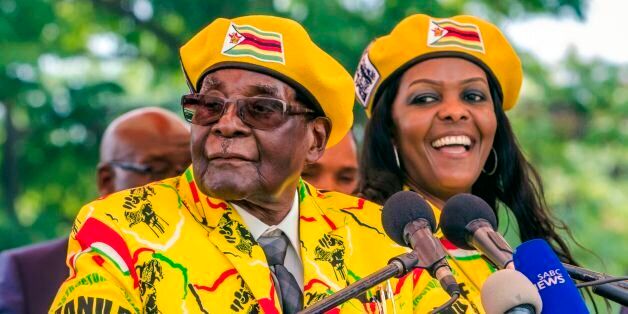 Zimbabwe's President Robert Mugabe (L) addresses party members and supporters gathered at his party headquarters to show support to Grace Mugabe (R) becoming the party's next Vice President after the dismissal of Emerson Mnangagwa November 8 2017.Zimbabwe's sacked vice president, Emmerson Mnangagwa, said on November 8, 2017, he had fled the country, as he issued a direct challenge to long-ruling President Robert Mugabe and his wife Grace. / AFP PHOTO / Jekesai NJIKIZANA        (Photo credit shou