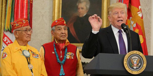 WASHINGTON, DC - NOVEMBER 27: (AFP OUT) U.S. President Donald Trump (R) speaks during an event honoring members of the Native American code talkers in the Oval Office of the White House, on November 27, 2017 in Washington, DC. Trump stated, 'You were here long before any of us were here. Although we have a representative in Congress who they say was here a long time ago. They call her Pocahontas.' in reference to his nickname for Sen. Elizabeth Warren. (Photo by Oliver Contreras-Pool/Getty Image