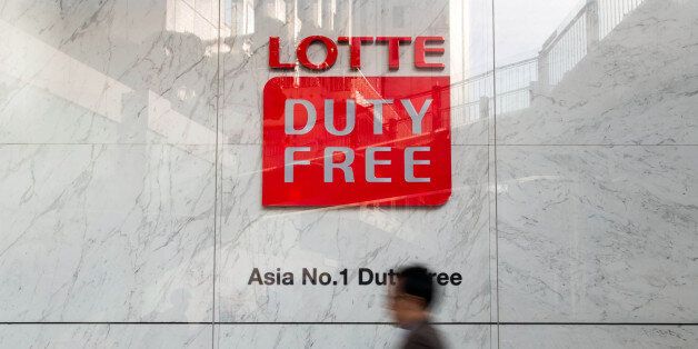 A man walks past signage for a Hotel Lotte Co. Duty Free store in Seoul, South Korea, on Monday, March 13, 2017. After almost seven years of planning and 4 trillion won ($3.6 billion) in spending,Â Lotte Group is preparing to unwrap its Lotte World Tower to the public.Â The building boasts some record-setting amenities: highest glass floor at the top of a building and highest swimming pool. Photographer: SeongJoon Cho/Bloomberg via Getty Images
