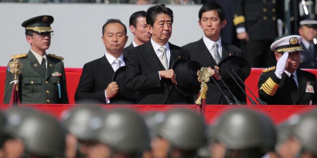 Japanese Prime Minister Shinzo Abe (C) reviews soldiers of the Ground Self-Defense Force during a military parade at Camp Asaka in Asaka, Saitama prefecture, on October 23, 2016.Some 4,000 personnel, 280 vehicles and 50 aircrafts took part in the military parade. / AFP / JIJI PRESS / JIJI PRESS / Japan OUT        (Photo credit should read JIJI PRESS/AFP/Getty Images)