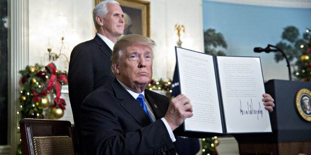 U.S. President Donald Trump holds up a proclamation next to U.S. Vice President Mike Pence, left, after making a statement on Jerusalem in the Diplomatic Room of the White House in Washington, D.C., U.S., on Wednesday, Dec. 6, 2017. Trump formally declared Jerusalem to be Israel's capital and is directing the State Department to start the process of moving the U.S. embassy there from Tel Aviv, a historic shift of U.S. policy that could inflame key allies. Photographer: Andrew Harrer/Bloomberg vi