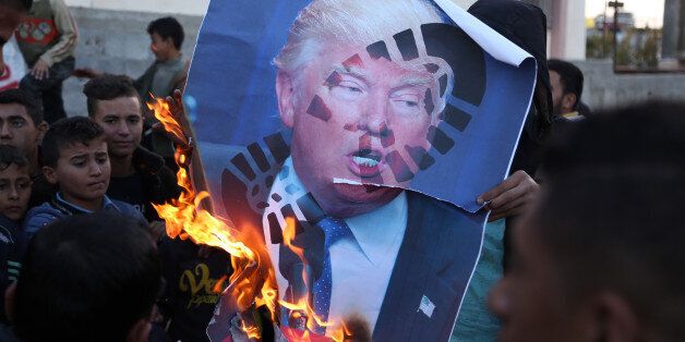 Palestinians burn posters of Israeli Prime Minister Benjamin Netanyahu and U.S. President Donald Trump, during a protest against the U.S. decision to recognize Jerusalem as Israel's capital, in Gaza City Thursday, Dec. 7, 2017. (Photo by Majdi Fathi/NurPhoto via Getty Images)