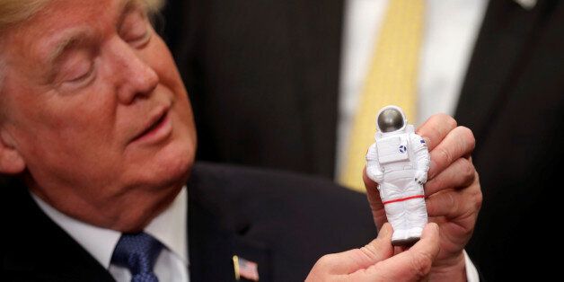 U.S. President Donald Trump holds a space astronaut toy as he participates in a signing ceremony for Space Policy Directive at the White House in Washington D.C., U.S., December 11, 2017. REUTERS/Carlos Barria     TPX IMAGES OF THE DAY