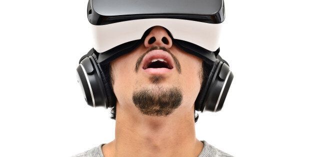 Young man wearing vr headset and handphones. Isolated on white. Wearable technology concept.