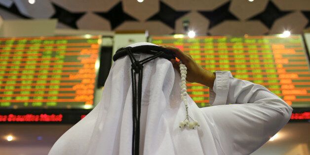 A visitor holds prayer beads while looking at financial information screens at the Dubai Financial Market (DFM) in Dubai, United Arab Emirates, on Tuesday, Nov. 10, 2015. Dubai's index declined for three straight months after a collapse in the price of crude battered economies in the oil-producing nations of the Gulf Cooperation Council. Photographer: Jasper Juinen/Bloomberg via Getty Images
