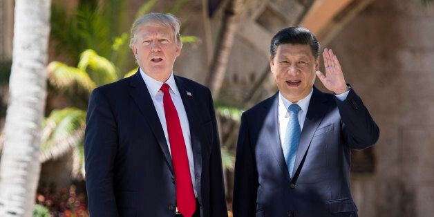 TOPSHOT - Chinese President Xi Jinping (R) waves to the press as he walks with US President Donald Trump at the Mar-a-Lago estate in West Palm Beach, Florida, April 7, 2017. / AFP PHOTO / JIM WATSON        (Photo credit should read JIM WATSON/AFP/Getty Images)