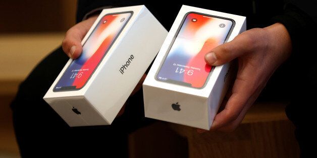 A man holds two boxes for the Appleâs new iPhone X which went on sale today, at the Apple Store in Regents Street in London, Britain, November 3, 2017. REUTERS/Peter Nicholls
