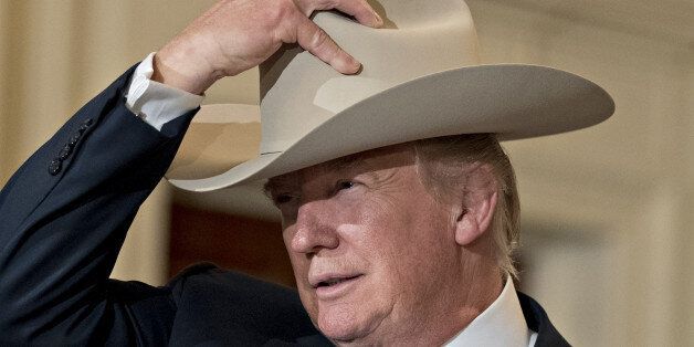 FILE: U.S. President Donald Trump puts on a Stetson cowboy hat while participating in a Made in America event, with companies from 50 states featuring their products, in the East Room of the White House in Washington, D.C., U.S., on Monday, July 17, 2017. The one year anniversary of U.S. President Donald Trump's inauguration falls on Saturday, January 20, 2018. Our editors select the best archive images looking back over Trumps first year in office. Photographer: Andrew Harrer/Bloomberg via Gett