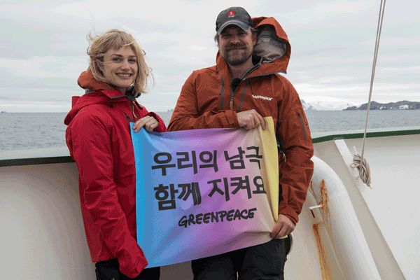 배우 데이빗 하버(오른쪽)와 배우 겸 가수 앨리슨 수돌이 그린피스의 환경감시선 아틱선라이즈호에서 남극해 보호 캠페인 배너를 들고 있다.