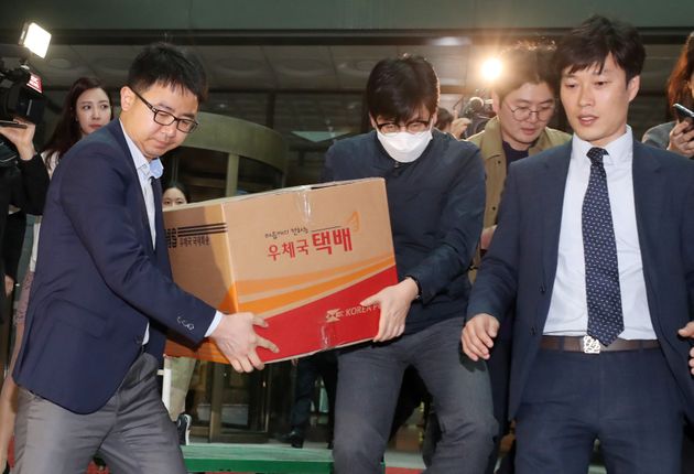 검찰 수사관들이 13일 오후 서울 여의도 한국거래소에서 김기식 금융감독원장 고발 사건 관련 압수수색을 마친 후 압수품을 옮기고 있다.