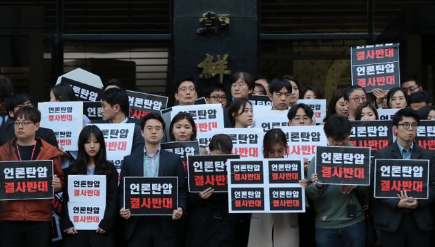 25일 오후 서울 중구 TV조선 사옥 앞에서 TV조선 기자들이 경찰의 압수수색에 반발하며 피켓을 들고 있다. 