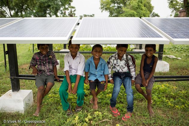 인도 Dharnai 마을의 어린이들이 태양광 패널 아래에 앉아 웃고 있다. 태양광 패널에서 생산된 전력은 마이크로 그리드를 통해 마을에 공급되고 있다.