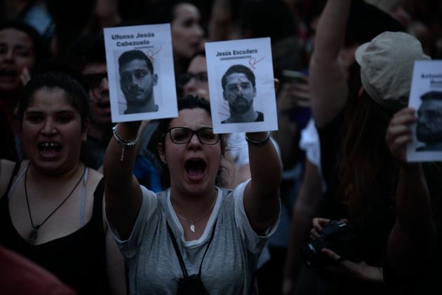 시위대가 집단 성폭행 가해 남성 5명 중 2명의 얼굴 사진을 들고 있다. 