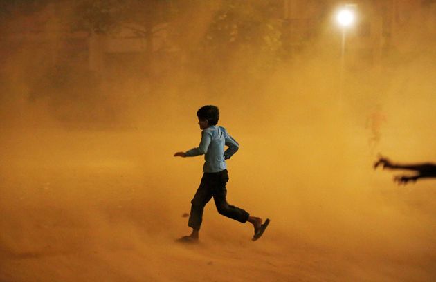 13일 인도 수도 뉴델리에서 모래 폭풍이 부는 가운데 한 소년이 뛰어가고 있다.