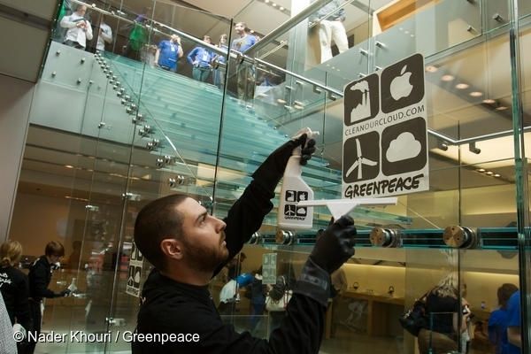 그린피스 활동가가 샌프란시스코  애플스토어에서 재생가능에너지로의 전환을 요구하는 캠페인 스티커를 붙이고 있다