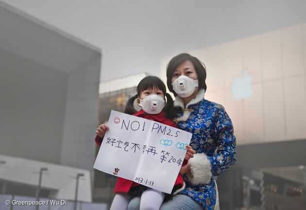 그린피스 캠페인에 참가한 한 어린이와 엄마가 '초미세먼지(PM2.5) 안 돼요!' 라고 쓰인 메시지를 들고 있다