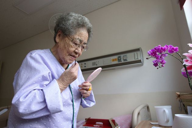 김복득 할머니가 2014년 7월 22일 경남도립 통영노인전문병원에서 매주 열리는 자원봉사자들의 노래자랑을 보러 가기 위해 립스틱 바르며 단장하고 있다. 