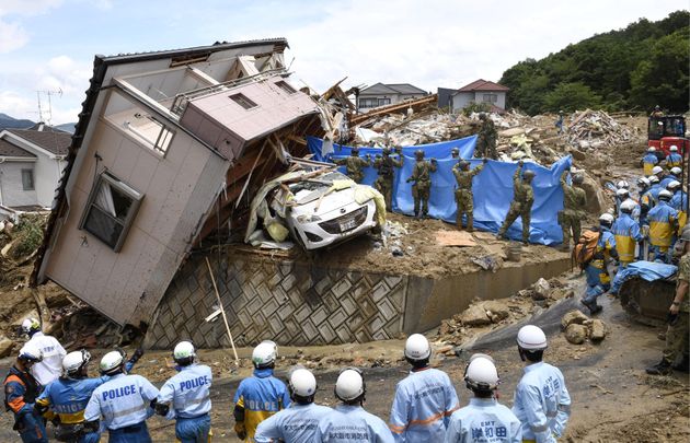 7월 9일 히로시마현 쿠마노쵸의 무너진 가옥에서 실종자를 찾고 있는 구조대원들. 