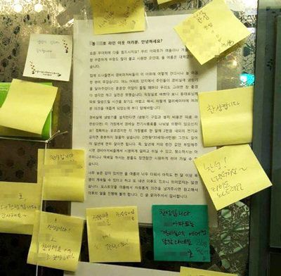 지난 3일 서울 방배동 신동아 아파트 주민 백은옥씨 부부가 내건 ‘경비실 에어컨 전기료 분납 제안서’에 이웃들의 동의 포스트잇이 줄줄이 붙어 있다.