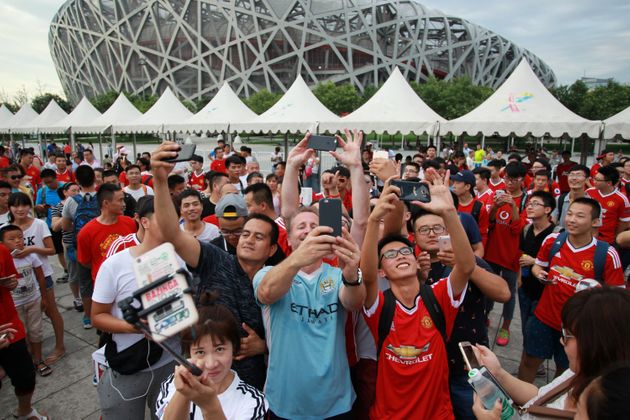 잉글랜드 프리미어리그(EPL) 맨체스터 유나이티드와 맨체스터시티의 유니폼을 입은 중국 팬들이 두 팀의 친선경기 직후 사진을 찍고 있다. 베이징, 중국. 2016년 7월25일.