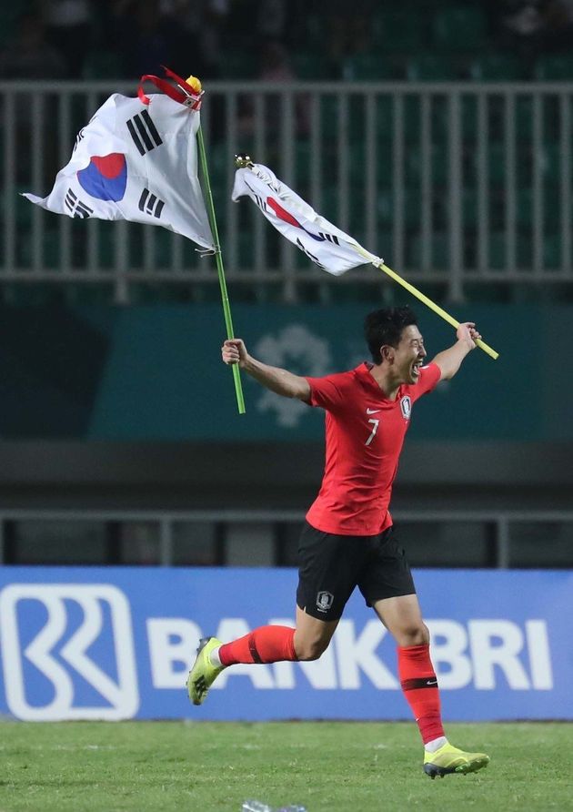 손흥민이 1일 저녁(현지시각) 인도네시아 보고르 치비농의 파칸사리 스타디움에서 열린 일본과의 2018 자카르타·팔렘방 아시안게임 남자축구 결승전에서 이긴 뒤 태극기를 들고 그라운드를 달리고 있다.