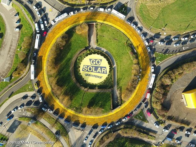 그린피스가 룩셈부르크에서 'Go Solar' 라고 적힌 배너 액션을 하고 있다
