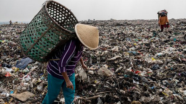 막 무지(55)가 인도네시아의 쓰레기 지대인 '반타 게방'의 산처럼 쌓인 쓰레기더미 꼭대기에서 플라스틱 등을 골라내고 있다. 자카르타의 1천5백만 이상의 인구가 배출하는 쓰레기들이 자카르타 바로 옆 도시인 베카시의 이 지역으로 모인다. 막 무지는 매일 새벽 마을에서 길 하나만 건너면 바로 닿는 이곳에서 쓰레기를 줍는다. 플라스틱, 유리, 신발, 철 등이다. 주운 것들은 등 뒤의 바구니에 모두 담은 후 나중에 분류해 재활용업체에 판다. 사진은 2017년 9월 19일.