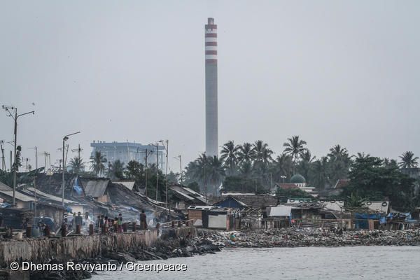인도네시아 반탄(Banten) 마을 뒤로 석탄화력발전소 굴뚝이 보인다. 이 곳의 주민들은 발전소에서 날아오는 석탄재로 인한 호흡기 및 피부 질환을 앓고 있다.