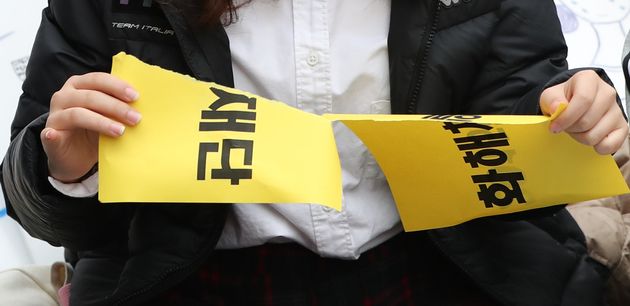 화해치유재단 해산이 공식 발표된 11월 21일 서울 종로구 옛 일본대사관 앞에서 열린 제1362차 일본군 성노예제 문제 해결을 위한 정기 수요시위에서 참석자들이 '화해치유재단'과 '2015한일협의'가 적힌 피켓을 찢고 있다. 