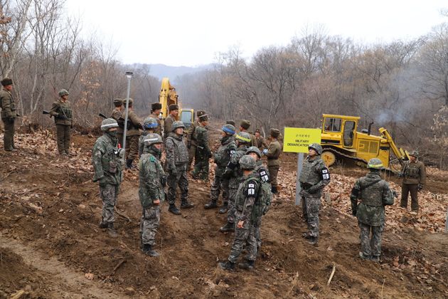 남북 군인들이 22일 중부전선 군사분계선 근처에서 만나 함께 도로연결작업을 하고 있다.