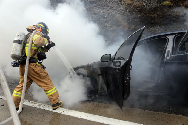 지난 8월20일 오후 경북 문경시 불정동 중부내륙고속도로 양평방면에서 달리던 BMW 승용차에서 화재가 발생해 119대원이 진화에 나서고 있다.