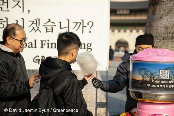 그린피스 활동가가 광화문광장에서 지나가는 시민에게 솜사탕을 나눠주고 있다