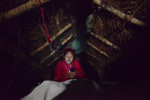 오두막에서 휴대폰을 들여다보고 있는 소녀
