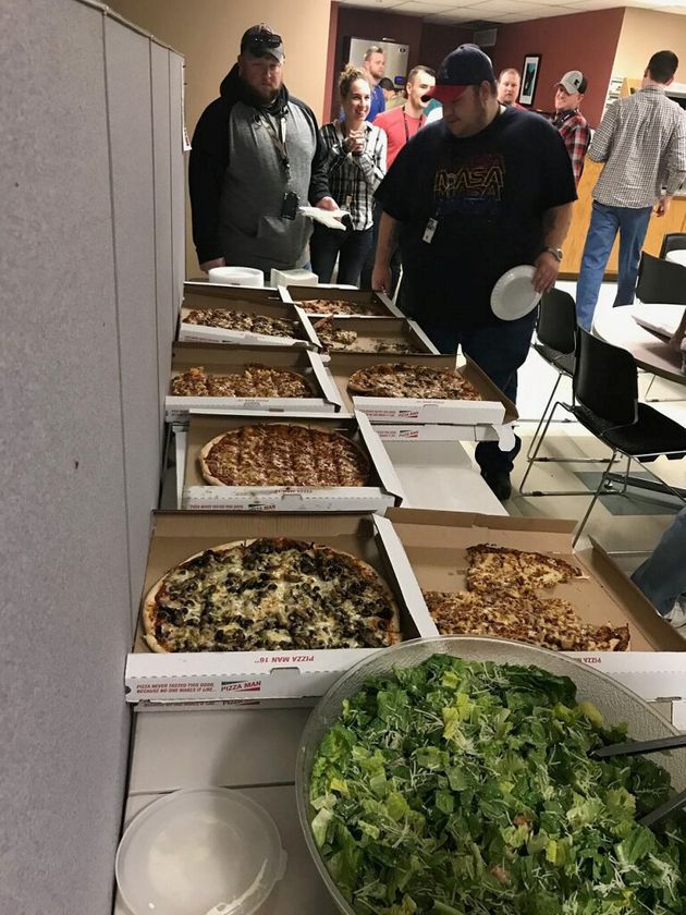 미네소타 미니애폴리스 관제 센터 직원들이 캐나다 위니펙 관제사들이 보내온 피자와 샐러드 앞에서 줄을 서고 있다. 2019년 1월11일.