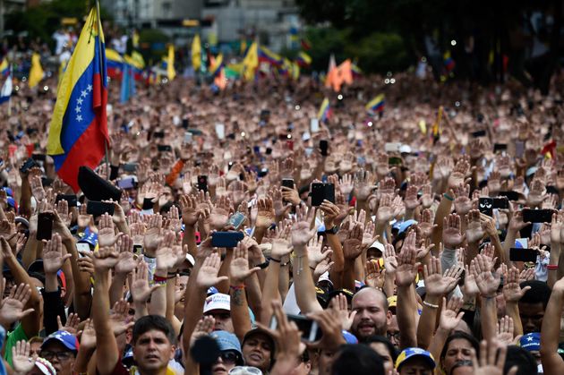 니콜라스 마두로 대통령 퇴진 촉구 대규모 시위에 참석한 시민들이 국회의장 후안 과이도가 스스로를 대통령 직무대행이라고 선언하자 손을 들어 지지를 보내고 있다. 카라카스, 베네수엘라. 2019년 1월23일.