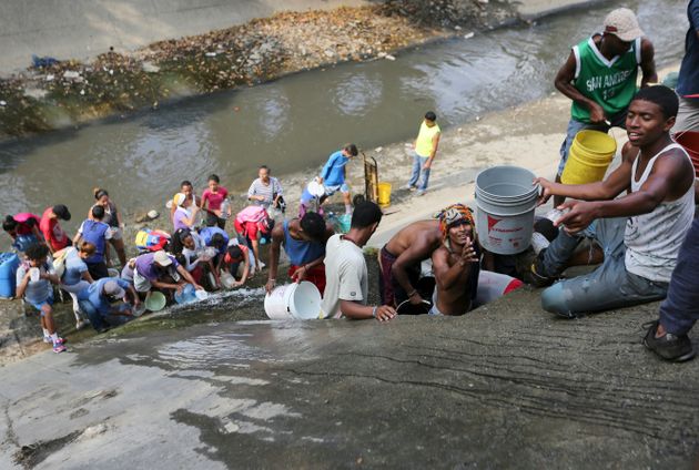 구아이레 강가에서 상수 파이프에서 새는 물을 모으고 있는 주민들