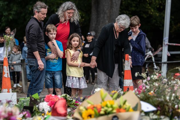 한 가족이 총기난사 테러 희생자들 앞에 조의를 표하고 있다. 뉴질랜드 크라이스트처치, 2019년 3월17일.
