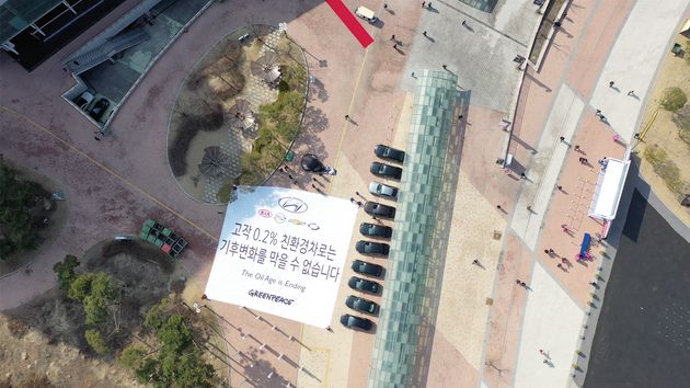 3월 29일 2019 서울 모터쇼 개막식 행사가 열린 경기 고양시 킨텍스 제 2전시관 앞에서 그린피스 활동가들이 ‘고작 0.2% 친환경차로는 기후변화를 막을 수 없습니다’라고 적힌 현수막을 펼치고 있다
